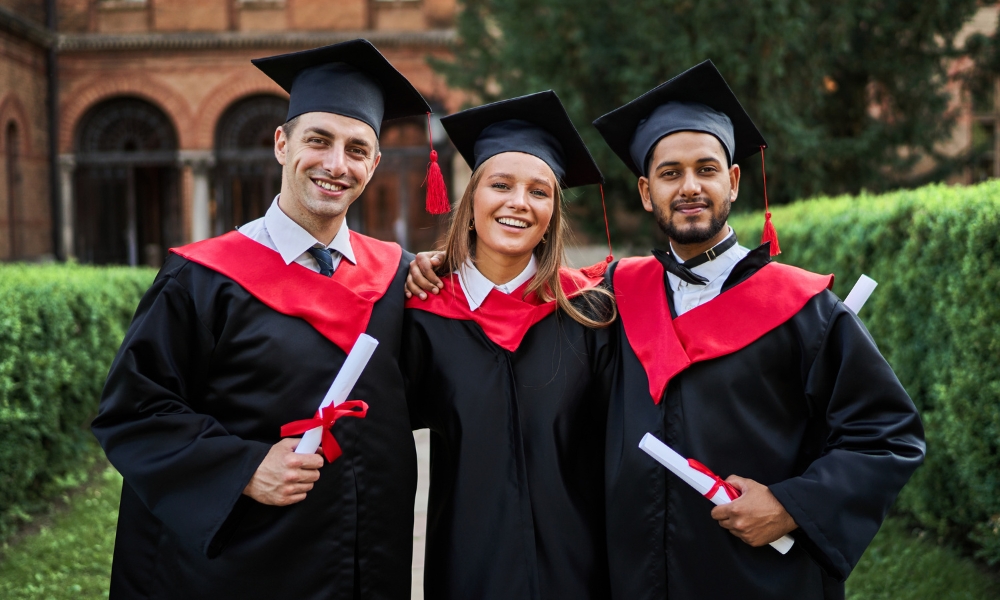 Group of graduates celebrating with diplomas on campus, symbolizing students choosing to study in Germany through study abroad consultants in Trichy.